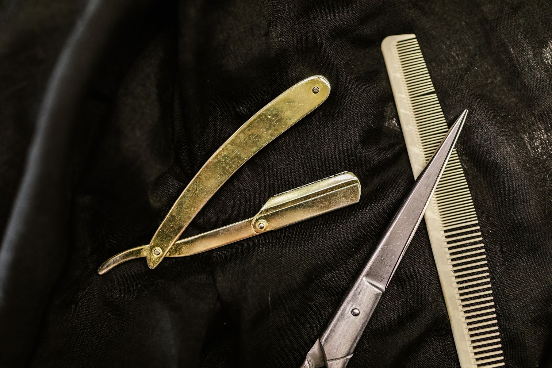 Barber tools on a dark cloth — stock photograph
